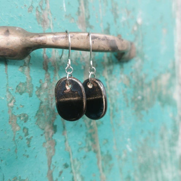 Handmade ceramic oval earrings, in black and bronze colore