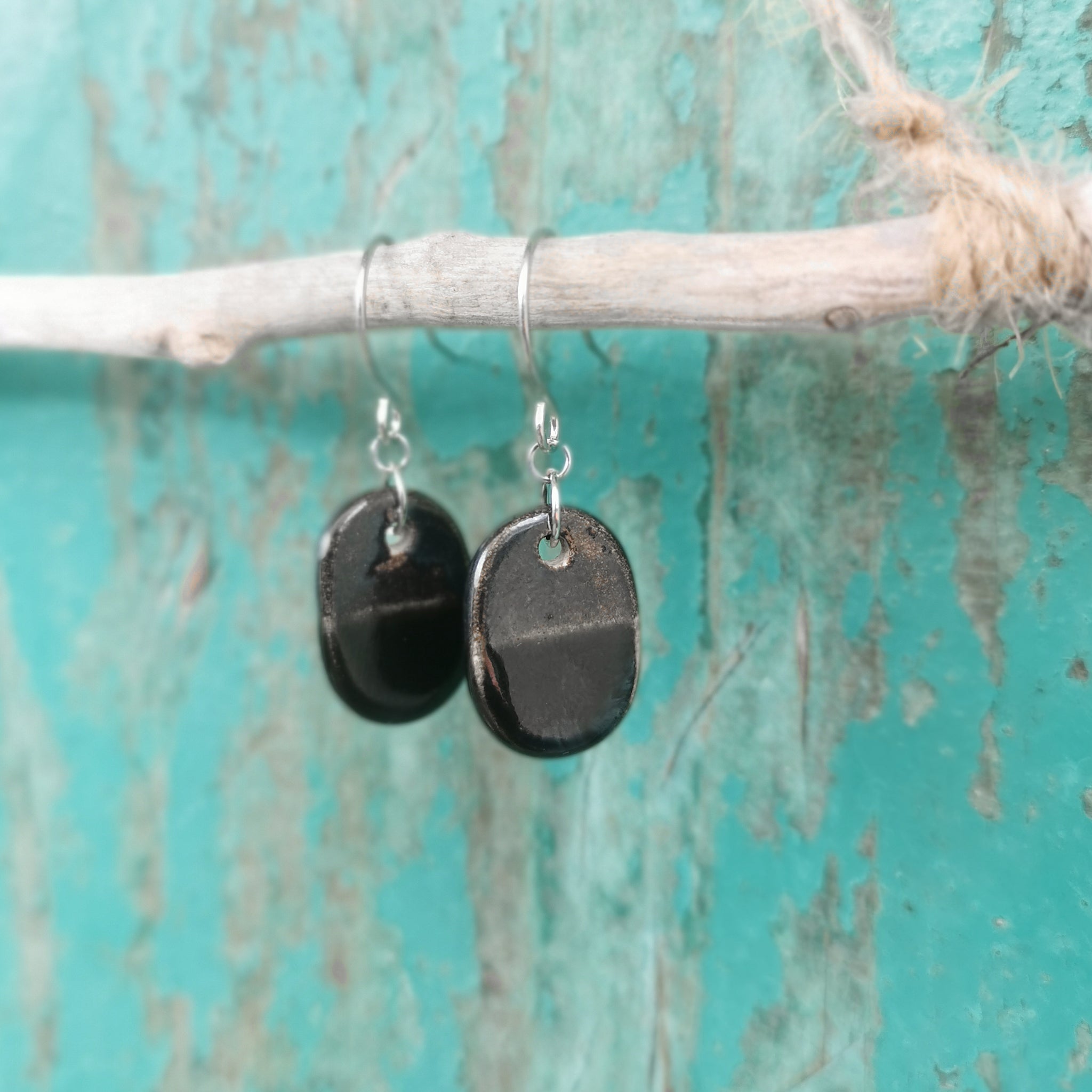 Handmade ceramic oval earrings, in black and bronze colore